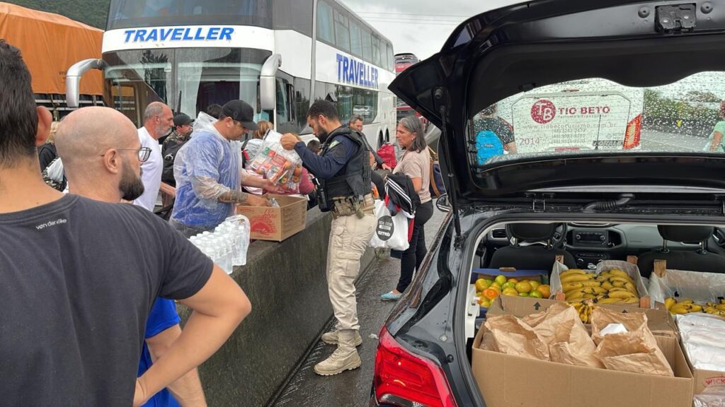 Policiais distribuem água e alimentos aos motoristas parados há quase 48 horas na BR101